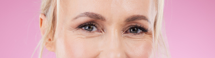 Image showing Beauty, eyes and portrait of woman on pink background for wellness, skincare and cosmetics in studio. Vision, cropped headshot and face zoom of happy female for eyesight, optometry and microblading