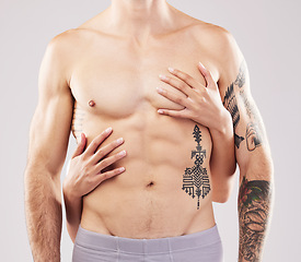 Image showing Woman, hands and touch on man chest, abdomen and muscle by studio background for sensual aesthetic. Model, anatomy and sexy with girl, tattoo and six pack for wellness, fitness and health by backdrop