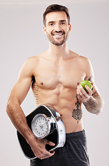 Image showing Health, diet and man, apple and scale, lose weight and smile in portrait, fitness and body, nutrition and fruit. Motivation for healthy lifestyle, weightloss and vegan, wellness on studio background