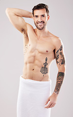 Image showing Clean, body and portrait of a man from the shower isolated on a grey studio background. Hygiene, grooming and happy shirtless model with a towel after a wash for a morning routine on a backdrop