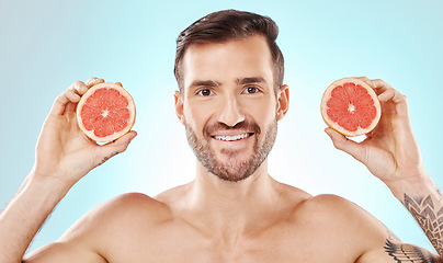 Image showing Man, skincare and studio portrait with grapefruit for health, nutrition and cosmetic wellness by blue background. Young model, fruit and vitamin c for natural detox, facial skin glow and aesthetic