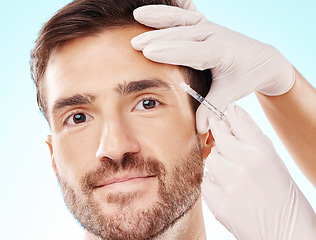 Image showing Portrait, man and needle for cosmetics, dermatology and beauty on blue studio background. Face, male and gentleman with skincare, injection and plastic surgery with botox, gloves and facial change