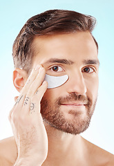 Image showing Face, skincare and man with eye patch in studio isolated on a blue background. Beauty, portrait and male model with pad product for dermatology, cosmetics and facial treatment, wellness and health.