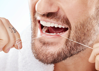 Image showing Dental, hygiene and man flossing his teeth in a studio for oral care, grooming or health. Wellness, healthy and closeup of male model doing fresh, clean and natural mouth routine by white background.