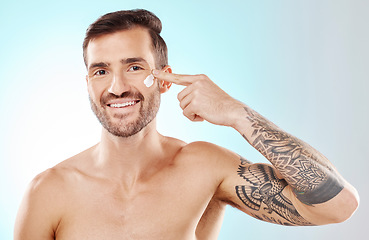 Image showing Skincare, beauty and portrait of a man with cream isolated on a blue background in studio. Glow, dermatology and model applying lotion or sunscreen for cosmetic grooming and treatment on a backdrop