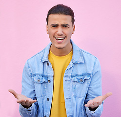 Image showing Confused, annoyed and portrait of a man in a studio with a doubt, upset and moody facial expression. Angry, mistake and male model doing sign language or hand gesture isolated by a pink background.