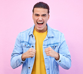 Image showing Portrait, winner and shouting in victory with a man in studio on a pastel pink background for cheering. Winning, celebration and screaming with a handsome young male celebrating against a wall