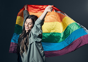 Image showing Flag, pride and happy woman, lgbtq and freedom to love, inclusion and equality, protest for human rights. Gay, trans and lesbian, politics and identity with community and rainbow on studio background