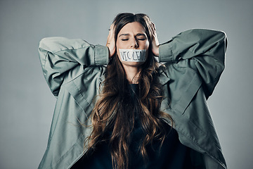 Image showing Woman, protest and tape on mouth in fear for cold war, armageddon or doomsday against gray studio background. Female activist with hands on head and message to stop or end global violence in society