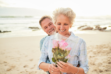 Image showing Gift, celebration and senior couple with flowers at the beach for love, care and gratitude in Spain. Happy, vacation and elderly man with a bouquet surprise for a woman on valentines day at the ocean