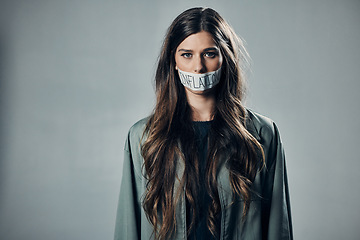 Image showing Woman, protest and tape on mouth for inflation, economic change or financial crisis against gray studio background. Portrait of female activist with message to end government greed or taxes on mockup