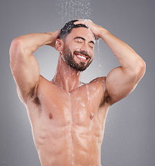 Image showing Shower, water and cleaning hair with a man in studio on a gray background for hygiene or grooming. Shampoo, haircare and washing with a happy or handsome young male in the bathroom keratin treatment