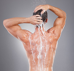 Image showing Shower, cleaning and back of man with soap on gray background for wellness, grooming and beauty. Skincare, bathroom hygiene and male smile for washing body, clean face and water for healthy skin