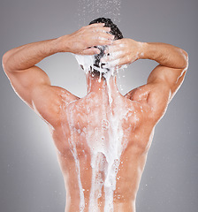 Image showing Shower, soap and back of man with water in studio on gray background for wellness, grooming and beauty. Skincare, bathroom hygiene and male smile for washing body, cleaning and soap for healthy skin