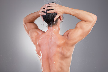 Image showing Shower, cleaning and back of man with water in studio background for wellness, grooming and beauty. Skincare, bathroom hygiene and male smile for washing hair, clean body and soap for healthy skin
