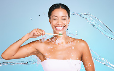 Image showing Bamboo toothbrush of black woman isolated on blue background with toothpaste, water splash and dental health. Model or person brushing teeth with eco friendly and sustainable product in studio mockup