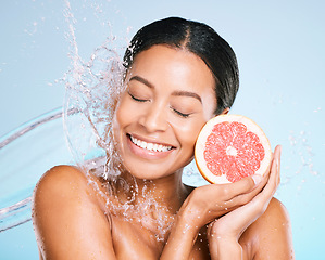 Image showing Skin care, beauty and woman with a grapefruit for healthy skin and diet on a blue background. Face of aesthetic model person with water splash and fruit for sustainable facial health and wellness