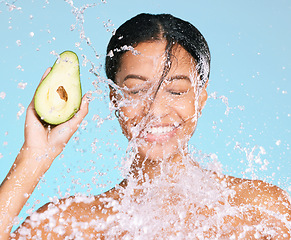 Image showing Beauty, water splash and woman with avocado for healthy skin and diet on a blue background. Face of aesthetic model person with skin care and green food for sustainable facial health and wellness