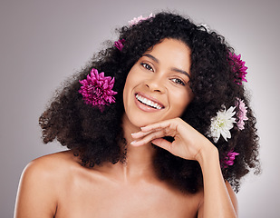 Image showing Face portrait, hair care flowers and black woman in studio isolated on gray background. Floral cosmetics, organic makeup and happy female model with flower for hairstyle, beauty skincare or wellness.