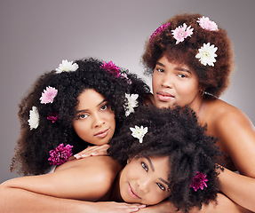 Image showing Hair care, friends and portrait of black women with flowers in studio isolated on gray background. Floral cosmetics, organic makeup and face of group of girls with flower for beauty and aesthetic.