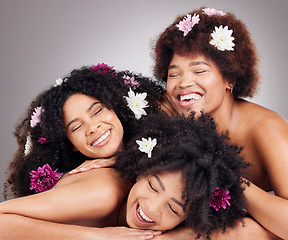 Image showing Friends, hair care and black women with flowers in studio isolated on a gray background. Floral cosmetics, organic makeup and face of group of girls or models with plants for aesthetic and beauty.