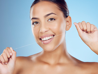 Image showing Floss, teeth and portrait of woman in studio for beauty, healthy body and hygiene on blue background. Female model, tooth flossing and cleaning mouth for facial smile, fresh breath and happy dental