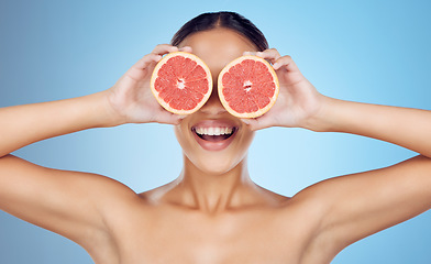 Image showing Grapefruit, woman and cover eyes for beauty on studio background, wellness benefits and smile. Skincare model, diet and citrus fruits for natural detox, healthy nutrition and happy face for vitamin c