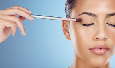 Image showing Makeup, woman with brush and cosmetics with dermatology, mockup and girl on blue studio background. Skincare, female and lady with equipment, foundation and morning routine for grooming and soft skin