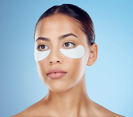 Image showing Black woman with collagen eyes mask isolated on blue background for skincare, beauty and facial cosmetics. Young model or person with dermatology eye patch, anti aging product and skin glow in studio