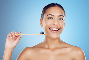 Image showing Brushing teeth, woman and portrait of bamboo toothbrush for dental healthcare, breath and cleaning cosmetics. Happy female, eco wooden brush and toothpaste for mouth, smile and studio blue background