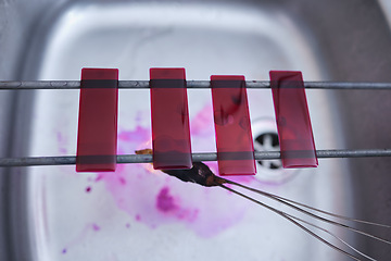 Image showing Red, blood and glass slide in laboratory stain research, dna cell engineering or acid particles chemistry in top view sink. Zoom, science and healthcare dye study in medical pharmacy with cotton swab