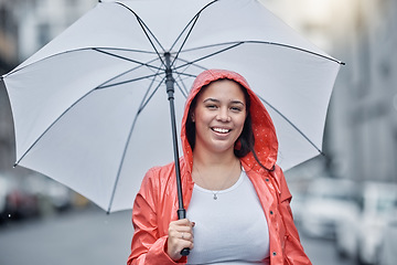 Image showing Umbrella, happy and portrait of a woman in the city walking in the rain while on a vacation. Travel, happiness and female with a red jacket on an outdoor walk in town on holiday in black and white.