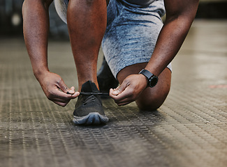 Image showing Hands, fitness and tie shoes in gym to start workout, training or exercise for wellness. Sports, athlete health and black man tying sneakers or footwear laces to get ready for exercising or running.