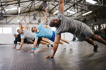 Image showing People, fitness and side plank in class with personal trainer for workout, stretching exercise or training. Diverse group in warm up stretch session with coach for cardio wellness or balance on floor