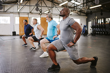 Image showing People, fitness and stretching legs in class with personal trainer at gym for workout, exercise or training. Diverse group in warm up leg lunge session with coach for cardio wellness on floor