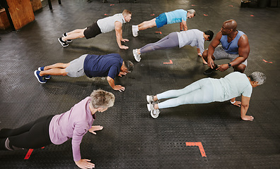 Image showing People, fitness and stretching in class with personal trainer at gym for workout, exercise or training. Diverse group in warm up plank session with coach for healthy exercising or strong core muscles