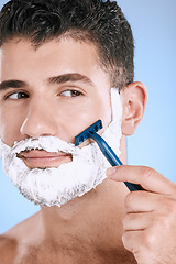 Image showing Shaving, beard and cosmetic man with cream for grooming isolated on a blue background. Skincare, beauty and model with razor to shave hair on face with foam for a clean facial look on a backdrop