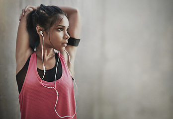 Image showing Fitness, focus woman and stretching with earphones on mockup space for exercise, workout and training. Serious female athlete warm up to music for runner motivation, mindset goals and sports energy