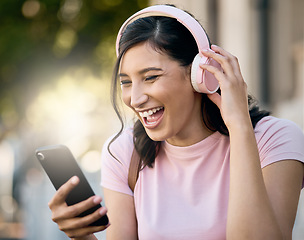 Image showing Headphones, music or video call by laughing woman in a city for travel, happy and joke on building background. Radio, podcast and funny meme for girl student with app, online audio or a positive post
