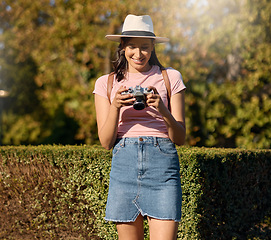 Image showing Photography, film and woman with a camera in nature for travel memory in Sweden. Summer, tourist and photographer looking at photos while traveling on a vacation in a park or botanical garden