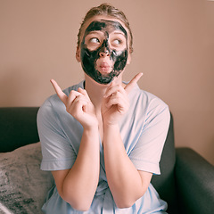 Image showing Skincare, face mask and goofy woman in her house, home or apartment doing morning beauty routine with hand gesture. Portrait, relax and funny female doing facial for self care using charcoal