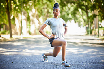 Image showing Black woman, fitness and stretching legs in preparation for running, cardio exercise or workout in nature. African American female in warm up leg lunges getting ready for exercising, run or training