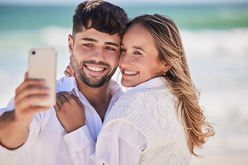 Image showing Beach, love and happy couple taking a selfie while on a date for valentines day, romance or anniversary. Happiness, smile and young man and woman hugging while taking picture by the ocean on vacation