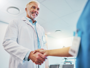 Image showing Healthcare, handshake and doctor in partnership with a nurse for a consultation in the hospital. Happy, smile and senior medical worker shaking hands with colleague for agreement in a medicare clinic