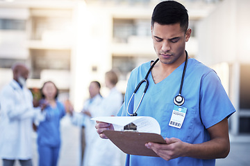 Image showing Healthcare, man and outdoor with clipboard, uniform and reading charts for results, focus and teamwork. Medical professionals, male employee and coworkers with information, diagnosis and documents