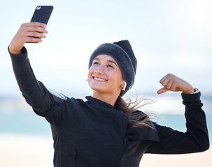 Image showing Fitness, woman and beach with smile for selfie, profile picture or social media post in muscle flex. Happy sporty female vlogger or influencer smiling for photo memory, exercise or workout outdoors