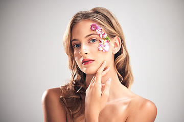 Image showing Flower art, beauty and portrait of woman for natural cosmetics, skincare wellness and makeup in studio. Spring, creative and girl with petal on face for spa aesthetic, luxury facial and cosmetology