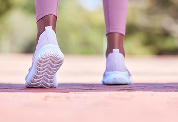 Image showing Runner athlete, woman and feet on pavement with blurred background ready for fitness and exercise. Road, run shoes and training of a female black person outdoor for sports, race and marathon