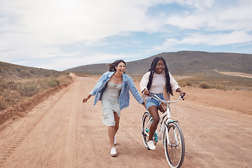 Image showing Bike ride, girl friends and road trip fun of women outdoor on a desert path on summer vacation. Cycling, running and freedom of young people together with bicycle transportation feeling free