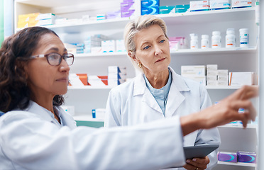 Image showing Pharmacist women, shelf and pointing together for retail, stock or product for medical wellness in store. Pharmacy training, management and teamwork for medicine, tablet and healthcare for solidarity